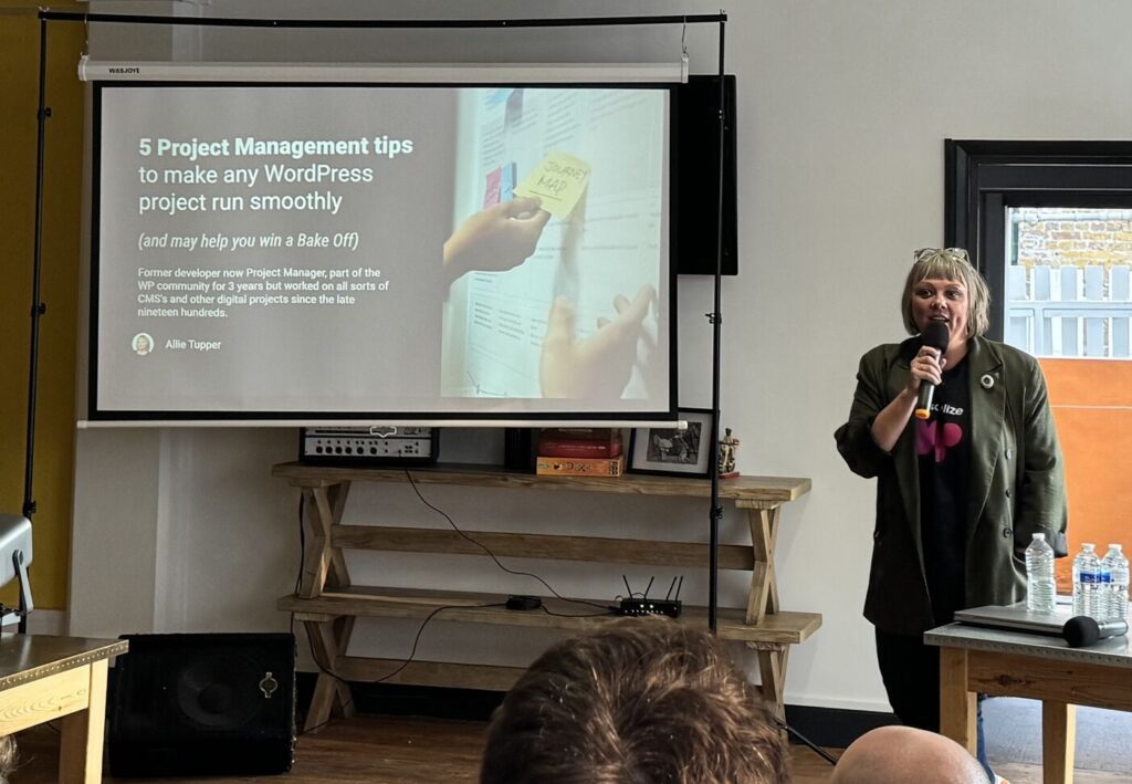 Allie speaking at WPLDN, holding a microphone in front of a slide reading 5 Project Management tips